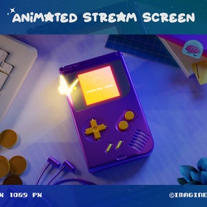 May include: A purple and yellow handheld video game console with a screen that says "STARTING GAME". The console is on a blue surface with a keyboard, headphones, and other objects.