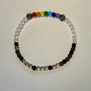 May include: A rainbow-colored beaded bracelet with silver paw print charms and clear beads.