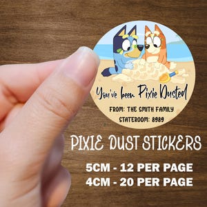 May include: Round sticker featuring cartoon dogs on a beach with the text "You've been Pixie Dusted." The sticker also includes the text "FROM: THE SMITH FAMILY STATEROOM: 8989" and "PIXIE DUST STICKERS". The sticker is available in 5cm and 4cm sizes.