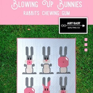 May include: A quilt pattern featuring six gray bunnies with pink bubble gum. The pattern is titled "Blowing Up Bunnies Rabbits Chewing Gum" and is from Art East Quilting Co. The quilt pattern measures 42 inches by 53 inches.