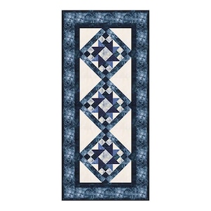 May include: A blue and white quilt runner with a geometric pattern. The runner features three diamond-shaped blocks with a starburst design in the center of each block.