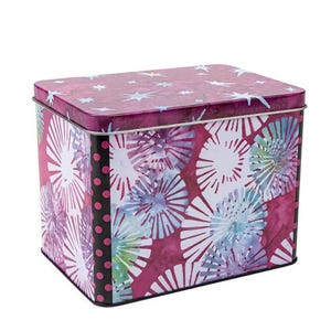 May include: A rectangular tin box with a lid. The box features a vibrant design of white, blue, and purple floral patterns against a deep magenta background. The lid has a star pattern. A black dotted stripe runs down one side.
