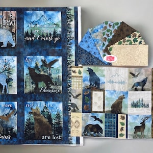 May include: A collection of fabric panels and fabric squares with a nature theme. The panels feature images of bears, wolves, deer, and mountains with inspirational text. The fabric squares have various nature-inspired patterns.