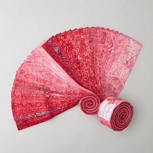 May include: A roll of 40 fabric strips in shades of pink and red with a floral pattern. The fabric is rolled up and tied with a white ribbon. The label on the roll reads "Tone on Tone".