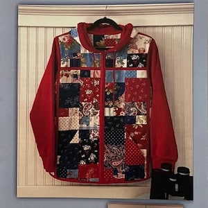 May include: A sewing pattern for a hoodie sweatshirt jacket titled Charming Hoodie Sweatshirt Jacket Pattern. The garment features a patchwork front panel with red, blue, and white floral and patterned fabric squares, red sleeves, and a hood.