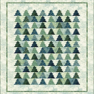 May include: A quilt with a pattern of green, blue, and white triangles arranged to form a repeating pattern of stylized pine trees. The quilt is framed with a green border.