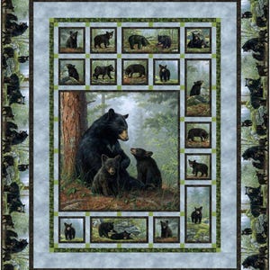 May include: A decorative quilt featuring a forest scene with black bears. The central image shows a mother bear with two cubs. Smaller framed images of bears are arranged around the central image. The border has additional bear images.