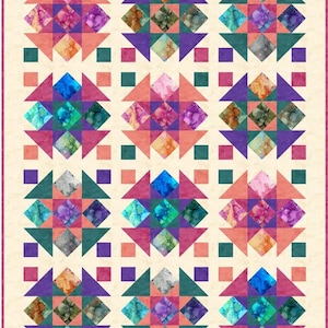 May include: A colorful quilt with a repeating pattern of star-like shapes. Each star features a diamond center with watercolor-style designs in shades of blue, purple, orange, and green. The quilt has a cream-colored background and a pink border.