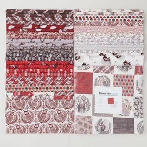 May include: A collection of fabric squares with various winter-themed patterns. Designs include owls, deer, trees, and geometric shapes in red, white, and brown. A small card with the brand name is visible.
