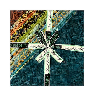 May include: A stack of patterned fabric strips in shades of teal, brown, and yellow, tied with a ribbon that reads "Island Batik." The fabric features geometric and abstract designs.