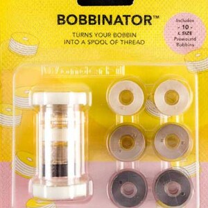 May include: A yellow and pink package containing a Bobbinator and prewound bobbins. The Bobbinator is a clear plastic device with white accents. The package includes 10 L size prewound bobbins. The text on the package reads "BOBBINATOR" and "TURNS YOUR BOBBIN INTO A SPOOL OF THREAD."