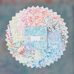 May include: A collection of colorful fabric squares arranged in a circular pattern. The squares feature various floral and abstract designs in shades of blue, pink, green, and yellow. A central stack of squares displays the text "Java Batik".