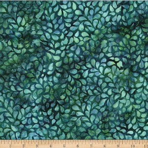 May include: A teal and dark green fabric featuring a repeating pattern of small, teardrop-shaped leaves. A white measuring tape is positioned along the bottom edge, showing a length of 11 inches across the width of the patterned textile material.