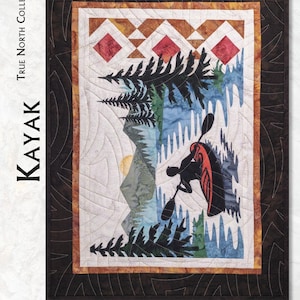 May include: A quilt pattern titled True North Collection Kayak featuring a silhouette of a person in a red kayak on blue water with pine trees and mountains. The design includes a dark brown border and text stating Framed 16 inches by 22 inches and Block 11 inches by 17 inches.