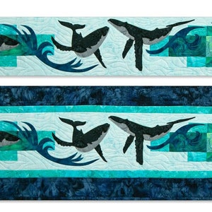 May include: A quilt runner featuring a repeating pattern of whales swimming through turquoise and blue waves. The whales are black and the waves are a mix of light and dark blue.