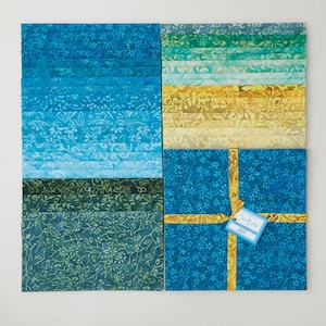 May include: A collection of batik fabric squares in shades of blue, green, and yellow. The fabric squares are arranged in a grid pattern, with some squares tied with a gold ribbon and a tag that reads "True Batik". The fabric has a floral pattern.