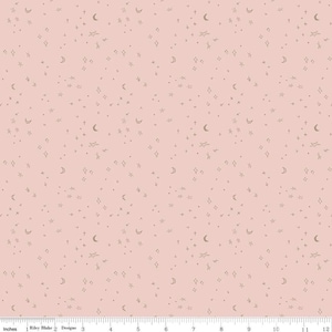 May include: A pink fabric with a repeating pattern of small stars, moons, and diamonds in a light brown color.