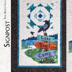 May include: A rectangular fabric quilt wall hanging featuring a black raven perched on a wooden signpost with three directional signs labeled Lake, Trail, and Camp. The design includes a geometric blue and white star pattern and mountain landscape.