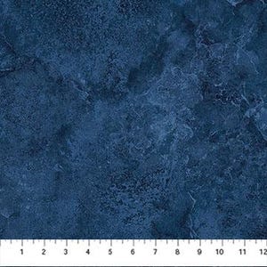 May include: Dark blue fabric with a marbled appearance. The fabric has a textured surface with lighter blue and white veining. A ruler is at the bottom, showing measurements in inches.