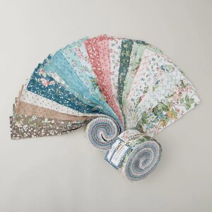 May include: A collection of fabric squares in various floral patterns and colors, including blue, pink, and green. The fabric is arranged in a fan shape, with two rolled bundles at the base. The fabric appears to be cotton, suitable for quilting or crafting projects.