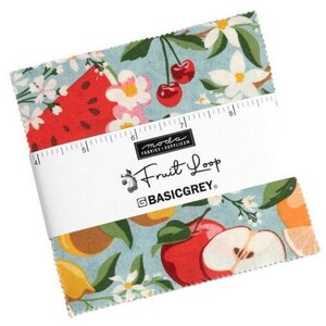 May include: A blue and white fabric square with a fruit print. The fabric features a watermelon, apples, lemons, cherries, and white flowers. The fabric is labeled "Fruit Loop" and "BASICGREY."