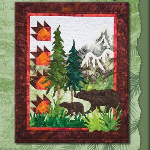 May include: A quilt pattern featuring a brown bear and a cub in a forest setting with mountains in the background. The pattern is called "Bear Country" and is a Marie Noah Sewing Pattern.