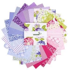 May include: A collection of fabric squares in a circular arrangement, featuring a variety of floral and patterned designs. The color palette includes shades of purple, pink, and green. The center displays a package with the text "In The Garden" and floral illustrations.