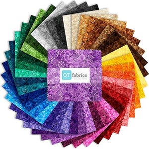 May include: A circular arrangement of fabric squares in a spectrum of colors, from deep blues and greens to vibrant reds and oranges. The center features a stack of purple fabric squares with the "QT fabrics" logo.