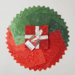 May include: A collection of red, green, and light green fabric squares arranged in a circular pattern. The squares have various floral and snowflake patterns. A bundle of red fabric squares is tied with a white ribbon and a tag that reads "Charm Squares".