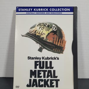 May include: DVD case for the film Full Metal Jacket, directed by Stanley Kubrick. The case features a black and green camouflage helmet with the words "Born to Kill" written on it. The title of the film is written in large, bold letters.