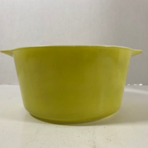 May include: A yellow ceramic mixing bowl with a white interior and rounded edges.