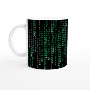 May include: White ceramic mug with a black and green design. The design features a pattern of green code on a black background.