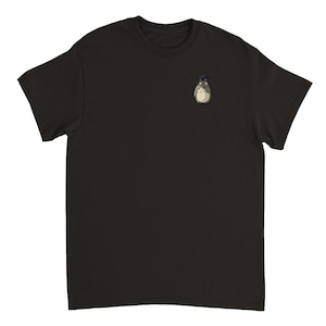 Op de afbeelding: Zwart T-shirt met een klein geborduurd beeld van een grijs en wit personage met een zwarte hoed.