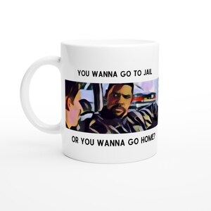 Puede incluir: Taza de cerámica blanca con una escena de la película "The Wire" impresa en ella. La taza presenta un primer plano de dos personajes, uno de los cuales dice "¿Quieres ir a la cárcel o quieres ir a casa?"