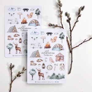 May include: Two sheets of stickers with a wilderness camping theme. The stickers are white with watercolor illustrations of a camper, tent, campfire, deer, owl, axe, and more. The text "Wilderness Camping" is on both sheets.