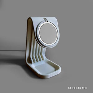 May include: A light grey charging stand with a circular charging pad. The stand has a curved design with a small tray at the base and vertical supports. The text "COLOUR #30" is visible at the bottom.