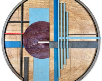 May include: A circular wooden wall art piece with geometric shapes in shades of blue, red, and brown. The piece has a modern abstract design.