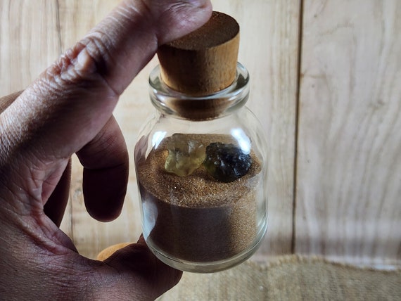 サハラ砂漠の砂をガラス瓶に詰め、リビア砂漠のガラスを添えたもの