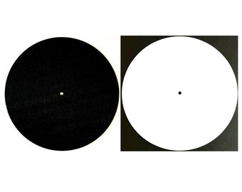 May include: Two circular objects on a white background. One is black with a small white dot in the center, and the other is white with a small black dot in the center, set within a black square.
