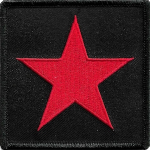 May include: A square black patch featuring a bold red star. The star is centrally positioned and has five points. The patch is bordered with stitching, providing a defined edge to the design.