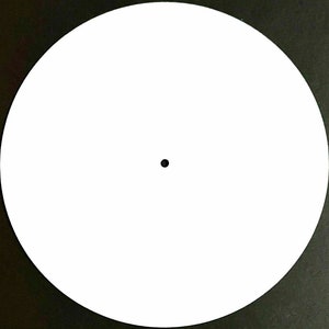 May include: A blank white circular object with a small black dot in the center, set against a dark background. The object is a perfect circle, and the dot is centered.