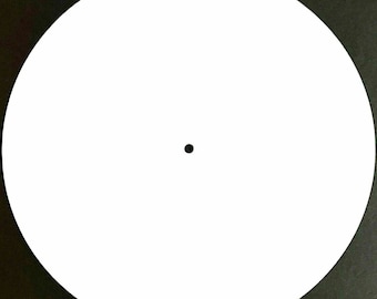 May include: A blank white circular object with a small black dot in the center, set against a dark background. The object is a perfect circle, and the dot is centered.
