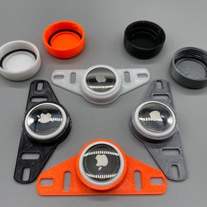 May include: Five different 3D printed Apple Watch bands in black, gray, white, and orange. Each band has a different design and features a small Apple logo on the front.
