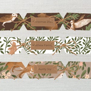 May include: Three Christmas crackers with animal illustrations and text. The top cracker has an owl and bear illustration with "Christmas 2025" text. The middle cracker has a bunny illustration with "Mathew Family" text. The bottom cracker has a fox illustration with "Aunty Joy" text.