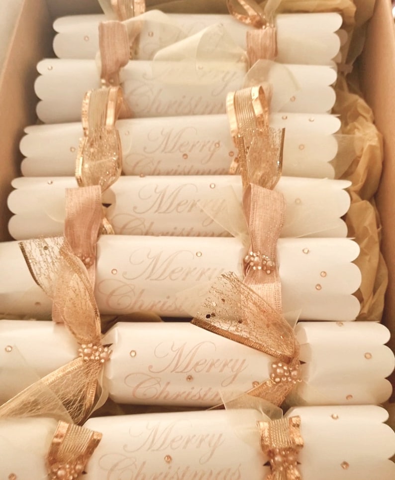 May include: A box of white and gold Christmas crackers with the text "Merry Christmas" printed on them.