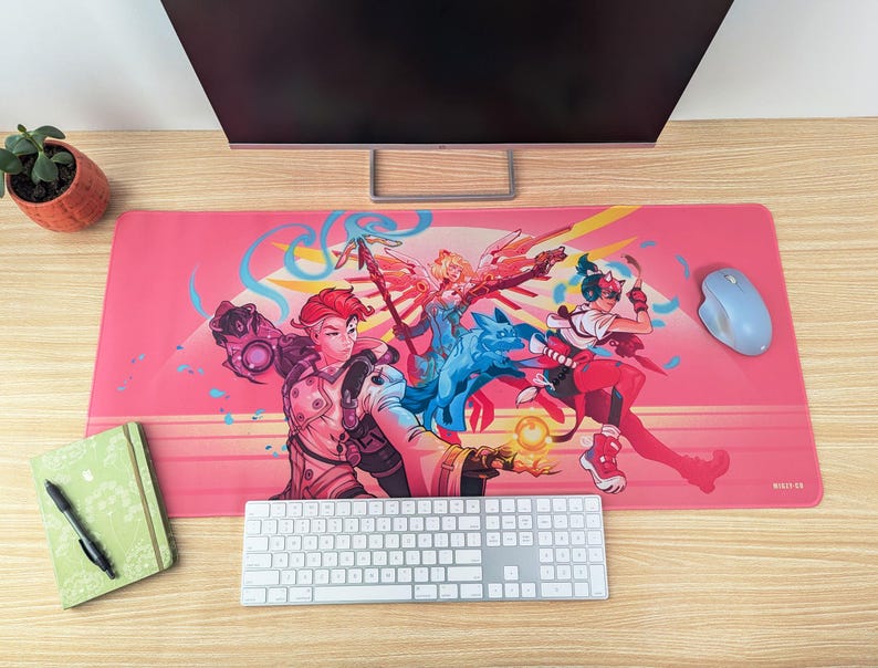 A top-down image of the desk mat, used as a mouse pad on a desk. There’s a keyboard, mouse, and monitor around it.