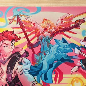 A close up of the pink mouse pad. You can see the three characters with the glowing blue dog in the middle. The middle character has wings and is holding a staff.