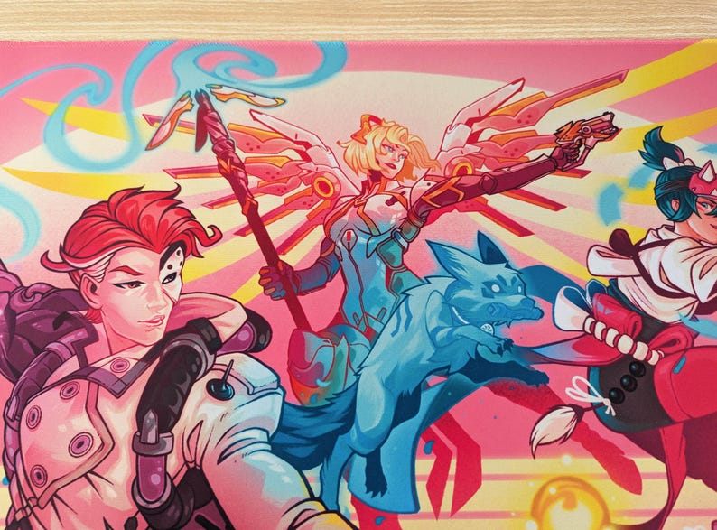 A close up of the pink mouse pad. You can see the three characters with the glowing blue dog in the middle. The middle character has wings and is holding a staff.