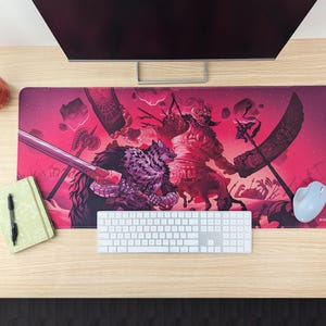 May include: A pink and red gaming mouse pad with a fantasy illustration of a wolf and a creature with horns and wings. The illustration is in a stylized, graphic style.