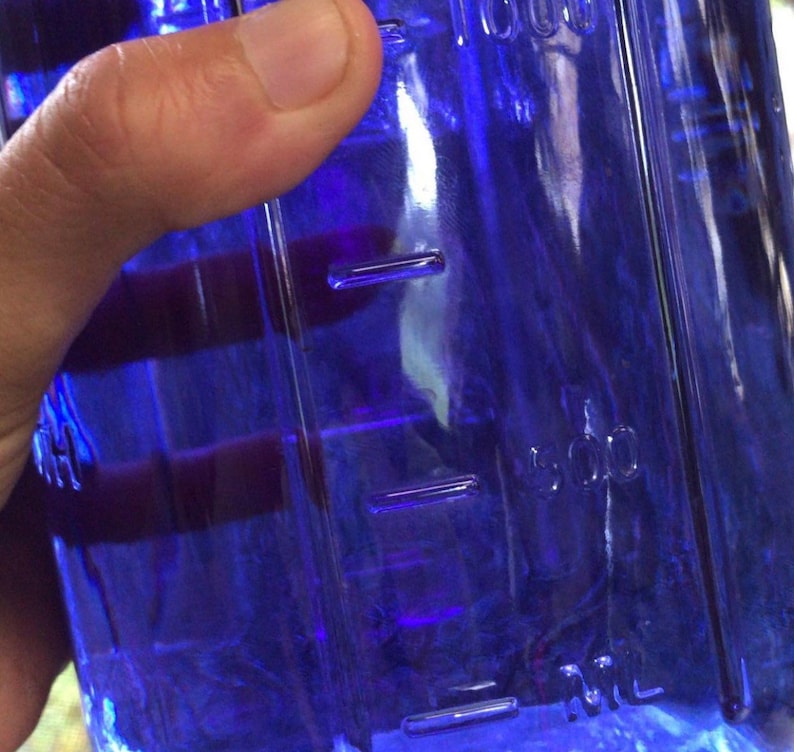 K&ouml;nnte beinhalten: Eine durchsichtige blaue Glasflasche mit einer 500 ml Messlinie. Die Flasche ist mit einer blauen Fl&uuml;ssigkeit gef&uuml;llt.